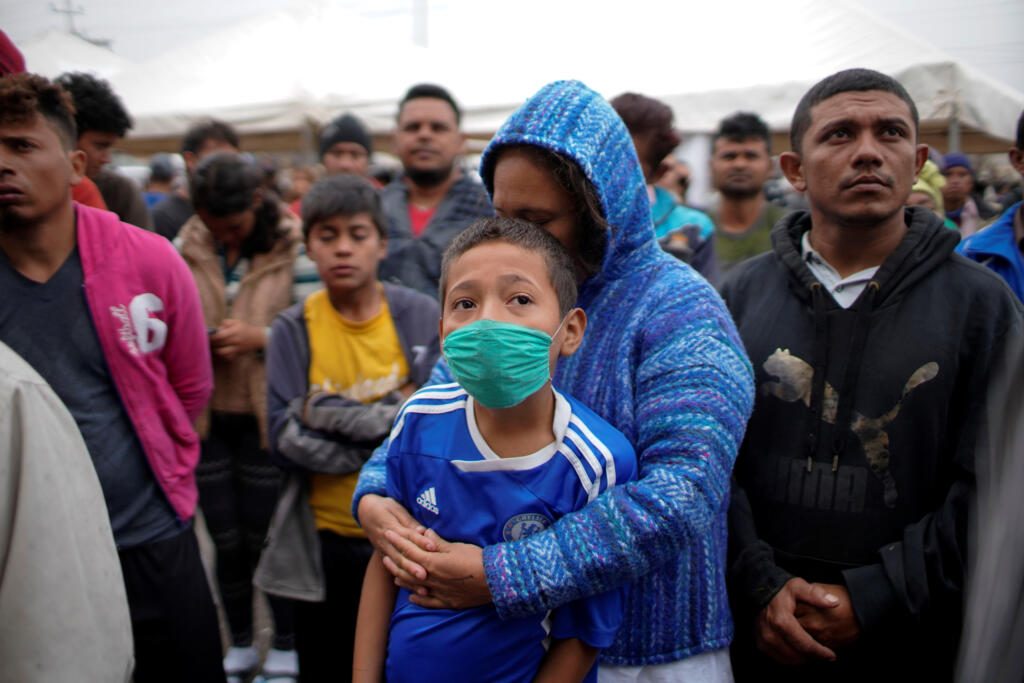 Migrants listen to Mexican authorities in a provisional shelter during their journey towards the United States, in Piedras Negras, Mexico